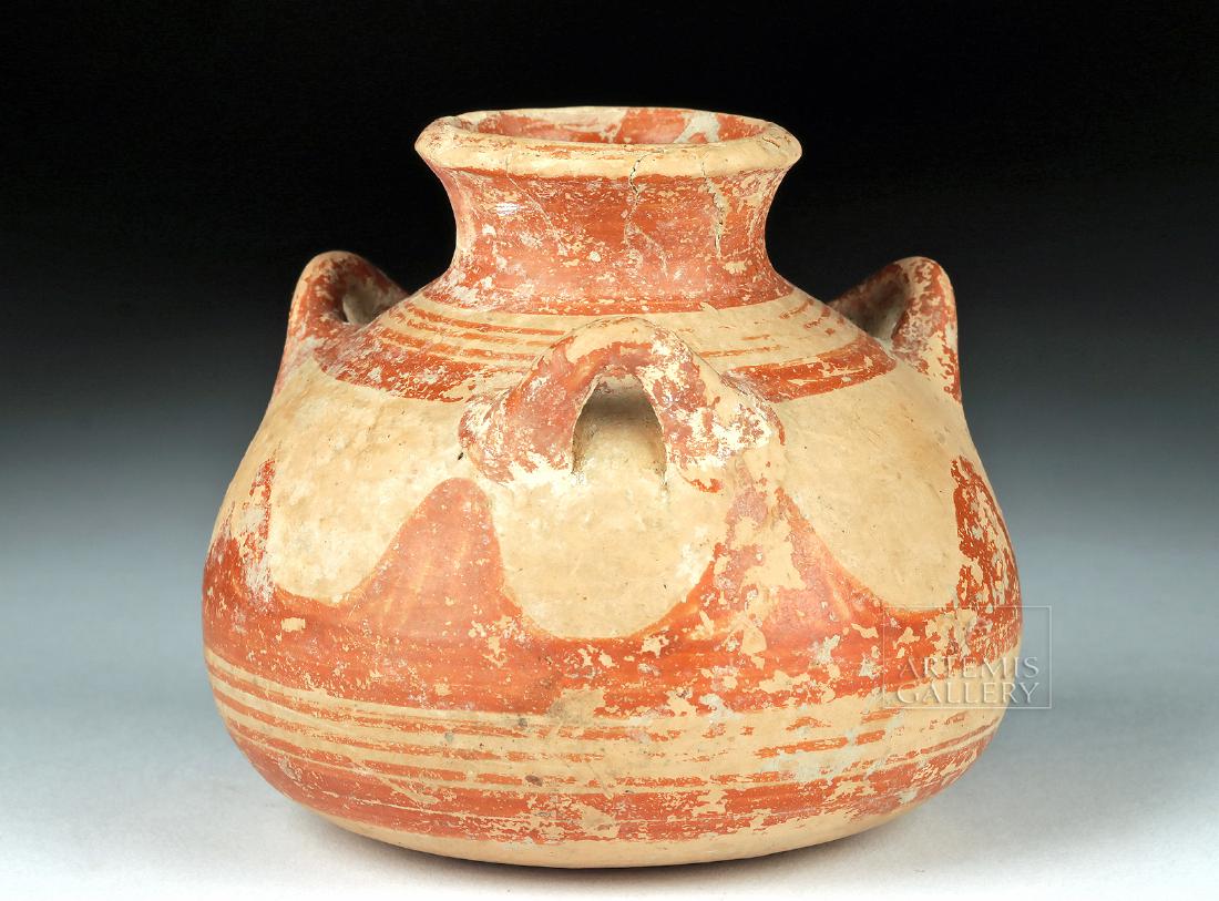 Myceanaean Pottery Pyxis w/ Three Handles: Ancient Greece, Mycenaean, Late Helladic III, ca. 1425 to 1100 BCE. A squat wheel-thrown pyxis which rests upon a slightly rounded base adorned with three red-painted concentric rings. The bi-chrome v