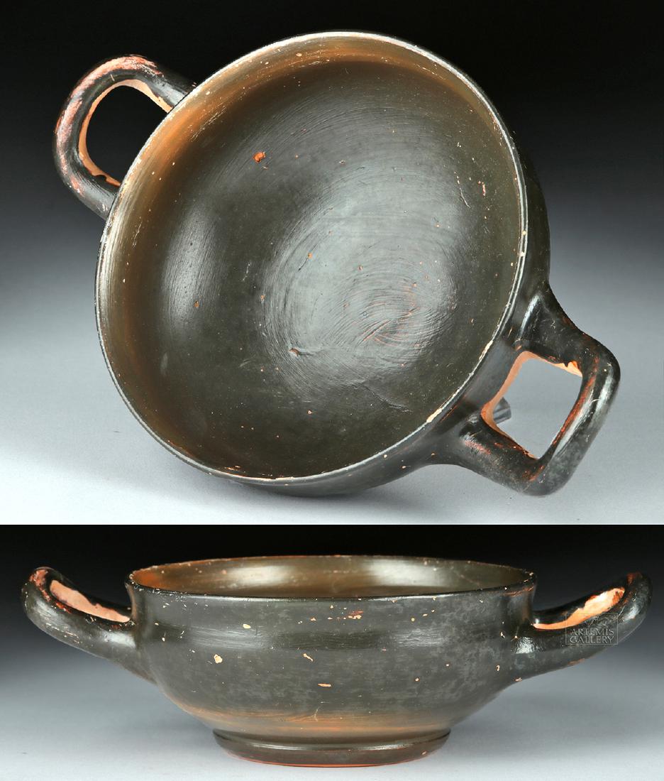 Greek Campanian Pottery Kylix w/ Maker's Initials: Magna Graecia, South Italic Colonies, Campania, ca. 360 to 320 BCE. A wheel-thrown kylix with a squat foot, a wide, shallow body, and a pair of applied parabolic handles. The majority of the exterior