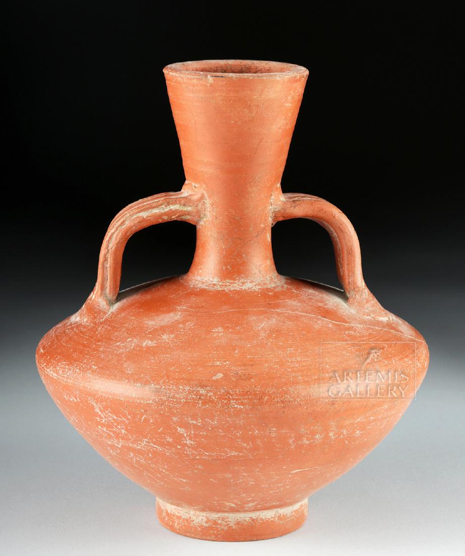 Roman Imperial Redware Flagon - Twin Handles: Roman, Imperial Period, ca. 1st to 2nd century CE. An elegant wheel-thrown red-slip flagon with a thick base, a wide flaring body with a rolled shoulder, a tall tubular neck with a flared rim, and a p