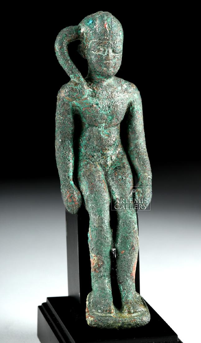 Egyptian Bronze Seated Harpocrates / Horus: Ancient Egypt, Late Dynastic Period, Dynasties 26 through 30, ca. 662 to 330 BCE. A seated bronze figure of the child god Harpocrates, sitting nude, legs together with feet on an integral square base,