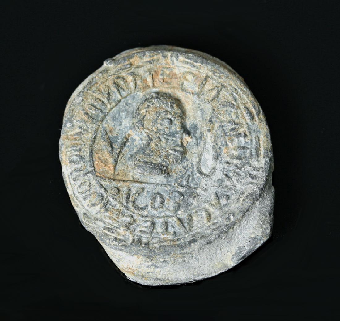 Roman to Byzantine Lead Seal: **Originally Listed At $150** Late Roman or early Byzantine Empire, ca. 4th to 6th century CE. A round, stamped lead seal, hollow on the back with a large lip and decorated on the front with a relief