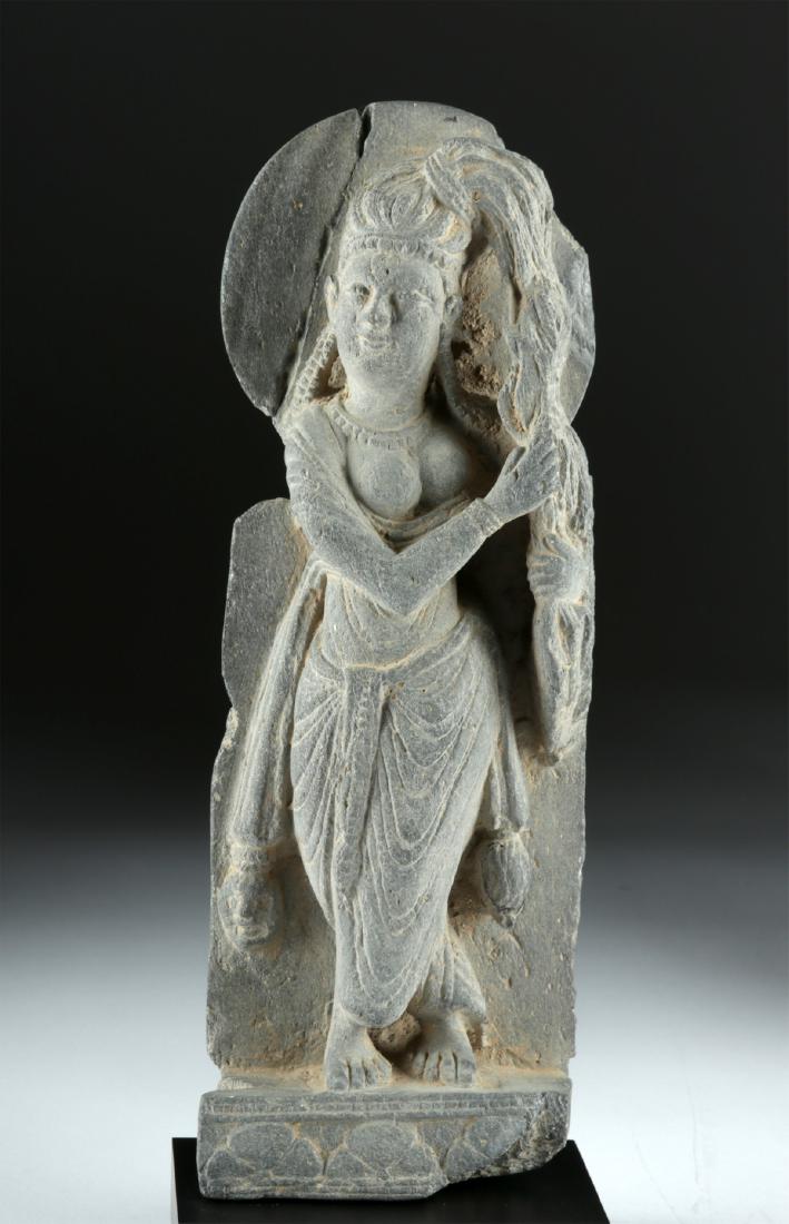 Gandharan Schist Standing Woman: Central Asia, Pakistan and Afghanistan, Gandharan Empire, ca. 1st century CE. A beautiful carved stone figure of a standing woman, her draped clothing carefully and realistically portrayed as it falls