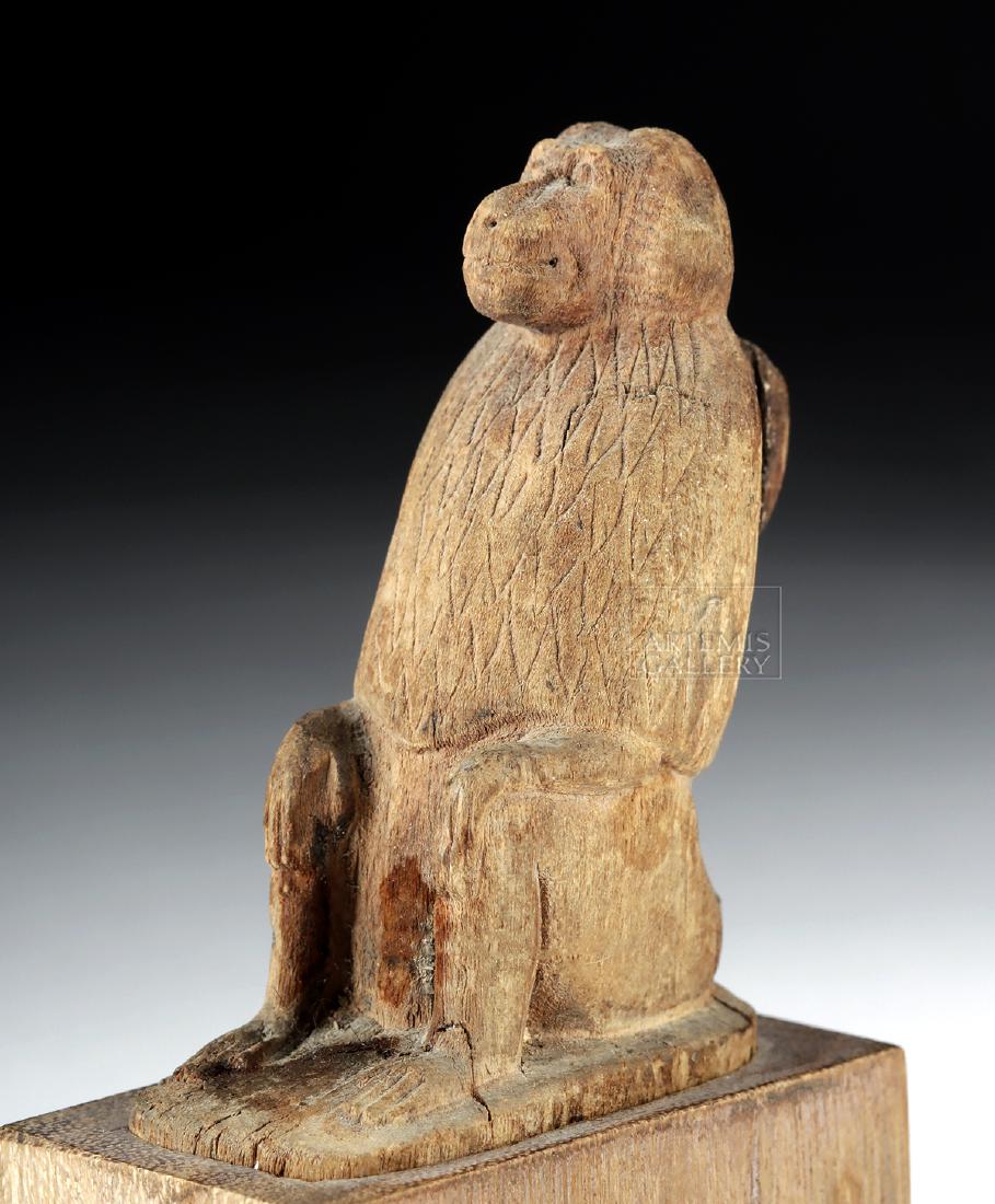 Rare Egyptian Late Period Wooden Thoth Amulet - Baboon: Egypt, Late Dynastic Period, 26th to 31st Dynasty, ca. 664 to 332 BCE. A charming, hand-carved wooden zoomorphic amulet of a baboon seated upon an integral ovoid plinth. The figure's arms rest upon be