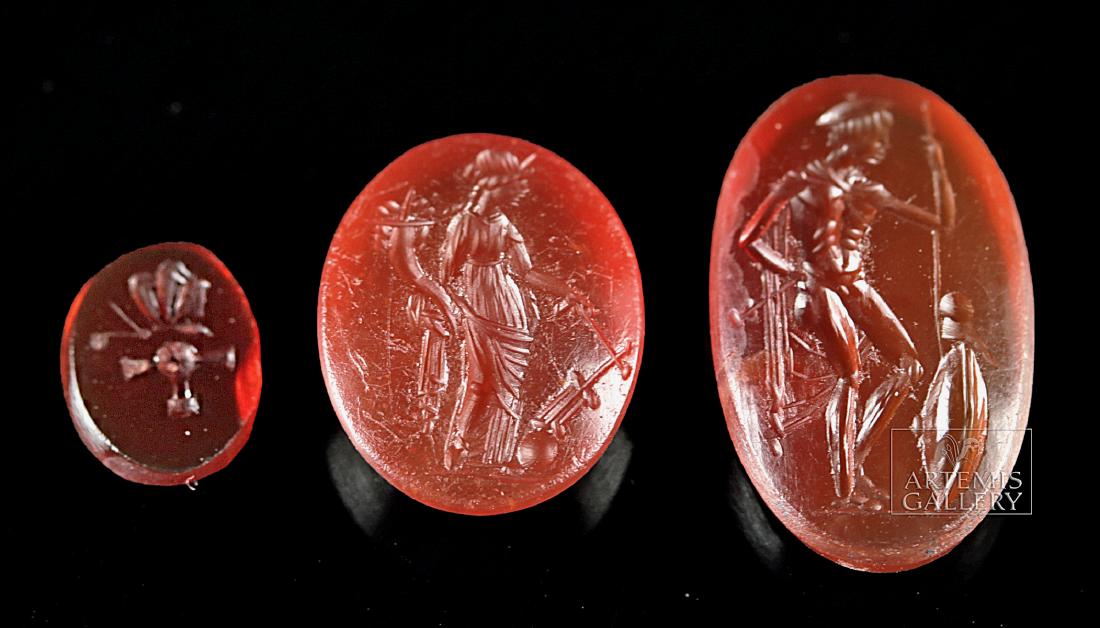 Lot of 3 Roman Carnelian Intagios: **First Time At Auction** Roman, Imperial Period, ca. 1st to 3rd century CE. Three gorgeous carnelian intaglios: a tiny one with an image of an altar, and two larger ones, one showing a tall, standing
