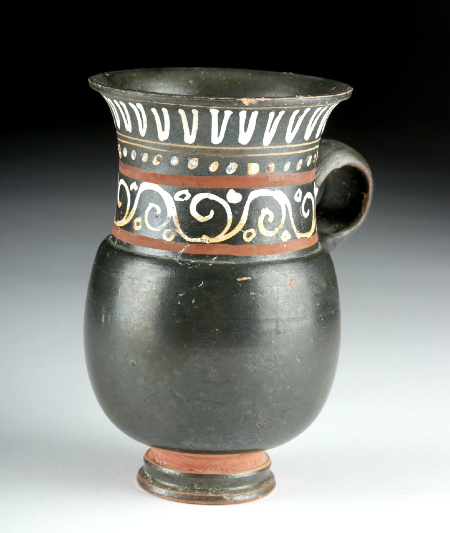 Choice Greek Gnathian Pottery Thistle Mug: Magna Graecia, Southern Italy, Apulia/Ignazia, ca. 340 to 320 BCE. A beautiful wheel-thrown pottery cup with a tiered footed base, a rotund body with an indented shoulder, a tall, flaring rim, and an