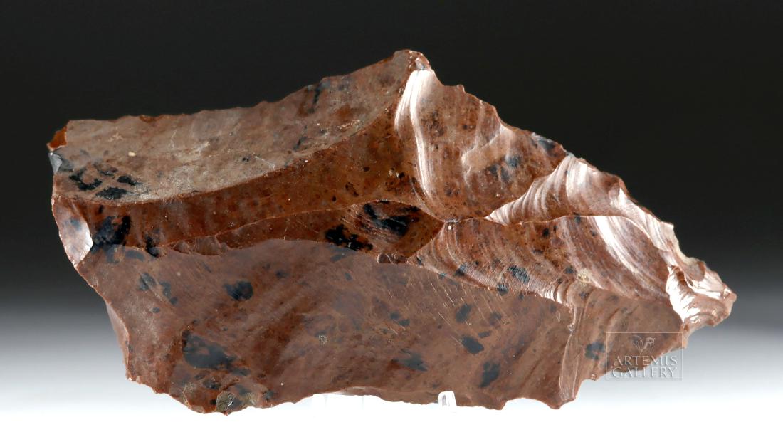 Rare Large Colima Red Obsidian Blade: Pre-Columbian, West Mexico, Colima, ca. 300 BCE to 300 CE. A mottled red and black obsidian blade, knapped to have edges that are still cuttingly sharp. Obsidian was revered by ancient Mesoamericans a