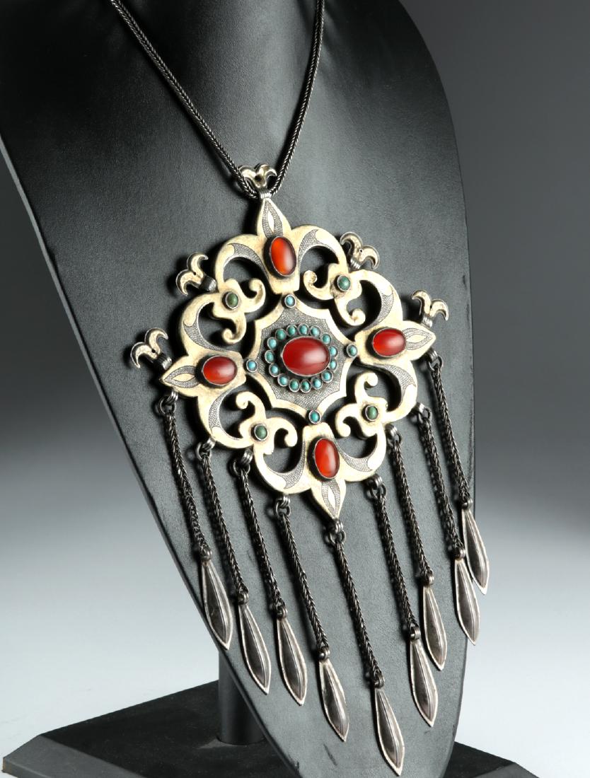 19th C. Teke Necklace - Silver, Carnelian, Turquoise: Central Asia / Iran, Teke (Tekke), ca. 19th century CE. A massive openwork pectoral ornament made of silver, fire-gilded and chased, with a gorgeous symmetrical form. Abstract ram's head terminals ris