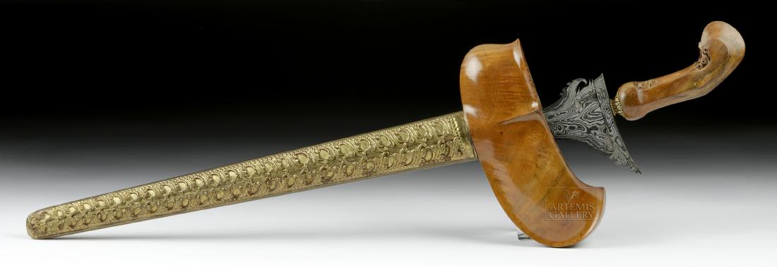 20th C. Indonesian Iron, Wood, Brass & Sapphire Kris: Southeast Asia, Indonesia, ca. first half of the 20th century CE. An elegant example of a ceremonial sword known as a kris (keris). The caramel-hued wooden handle displays a pair of abstract masks on 