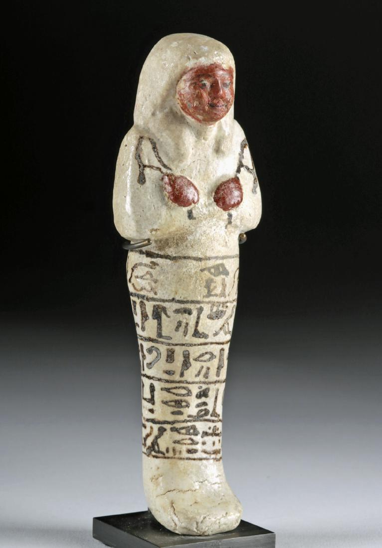 Fine Egyptian New Kingdom Glazed Faience Ushabti: Ancient Egypt, New Kingdom, Ramesside Period, 19th Dynasty, ca. 1279 to 1213 BCE. A gorgeous mold-formed faience ushabti covered in a clear glaze to show the white coloration beneath. The figure stand
