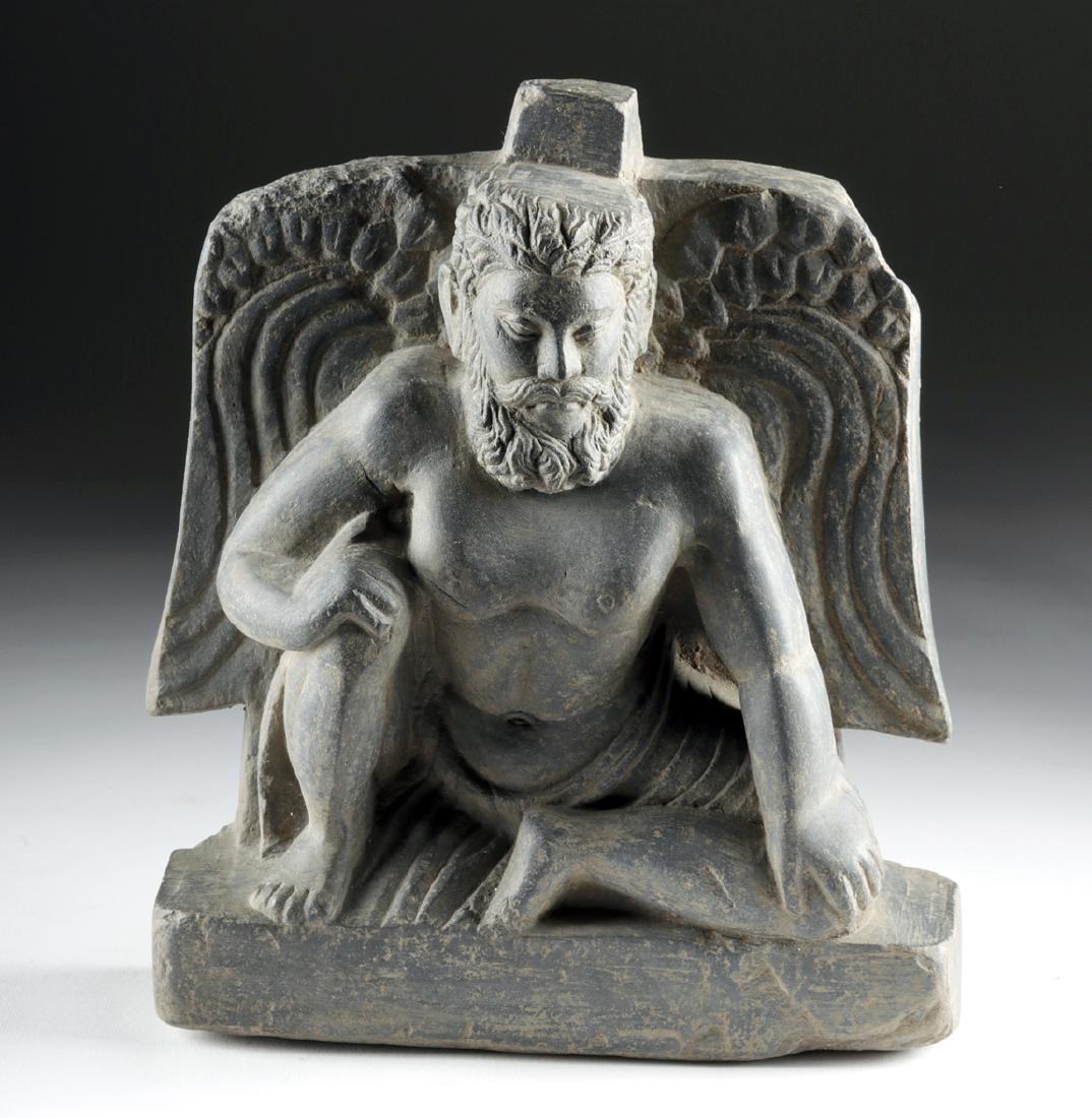 Gandharan Schist Relief of Seated Winged Atlas: Ancient Central Asia, Pakistan, India, and Afghanistan, Gandharan Empire, ca. 1st to 3rd century CE. A finely-modeled relief sculpture depicting the Greco-Roman deity Atlas in a seated position atop a