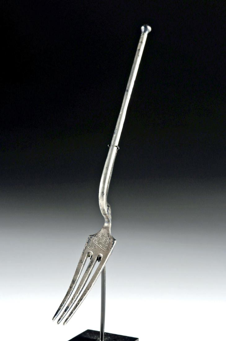 Rare Byzantine Incised Silver Fork - 21.6 grams: Near East/Holy Land, Byzantine Empire, ca. 12th to 15th century CE. An incredibly rare 92% silver fork of delicate form, with incised motifs above its tines. The handle is long and thin, capped by a s