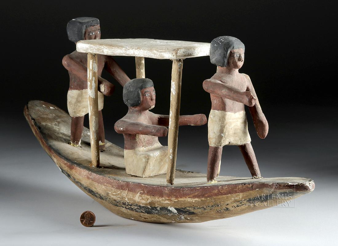 Egyptian New Kingdom Wooden Boat & Boatmen: Ancient Egypt, New Kingdom, ca. 1550 to 1069 BCE. A hand-carved and hand-painted wooden boat with three oarsmen! The men at the front and rear ends of the vessel are standing with their arms extending