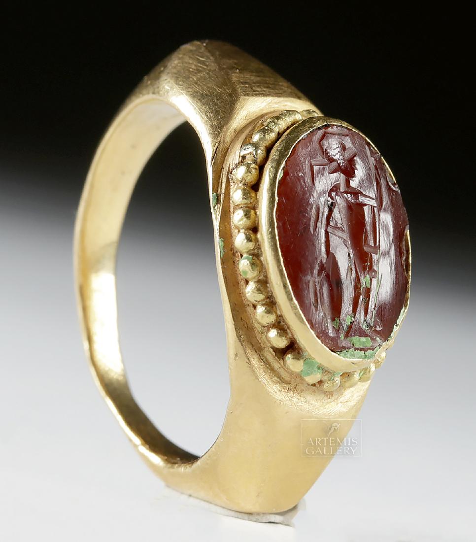 Roman 22K+ Gold Ring w/ Carnelian Intaglio of Warrior: Roman, Imperial Period, ca. 1st to 3rd century CE. A striking ancient Roman ring, with a handsome gold setting comprised of 92% gold (equivalent to 22K+), the style a signet variant with a 'beaded' bo