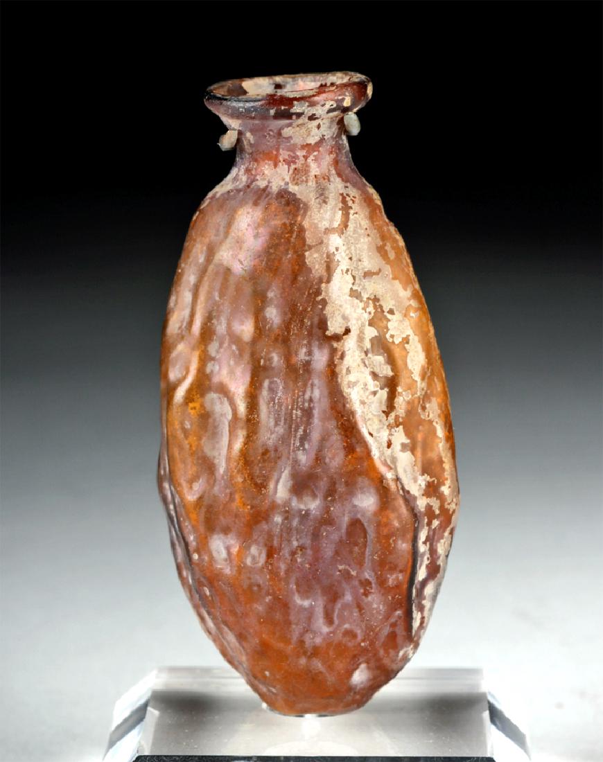 Roman Sidonian Glass Date Flask, ex-Christie’s: Roman Empire, Lebanon, Sidonian, ca. mid 1st to early 2nd century CE. A fine mold blown flask resembling a date fruit in gorgeous translucent amber glass with hints of aubergine - its generally oblong