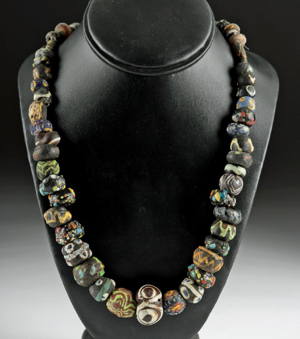 Superb Roman / Byzantine Glass Bead Necklace: Roman Imperial to Middle Byzantine Period, ca. 300 to 1200 CE. A beautiful collection of fifty-eight ancient Roman and Byzantine beads, made from glass and stone, strung on a modern necklace strand ca