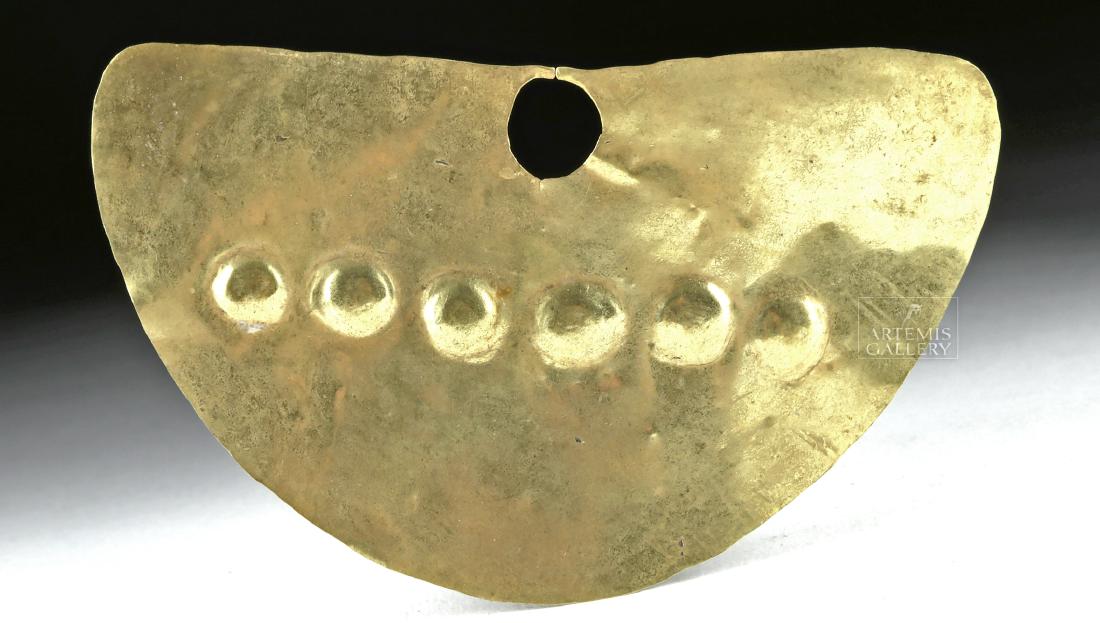 Impressive Moche 18K Gold Nose Ring, 10.1 g: Pre-Columbian, North Coast Peru, Moche culture, ca. 100 to 700 CE. An impressive hammered 18K gold sheet nose ring of a sizable form with two small prongs above a circular opening. Six small hemispher