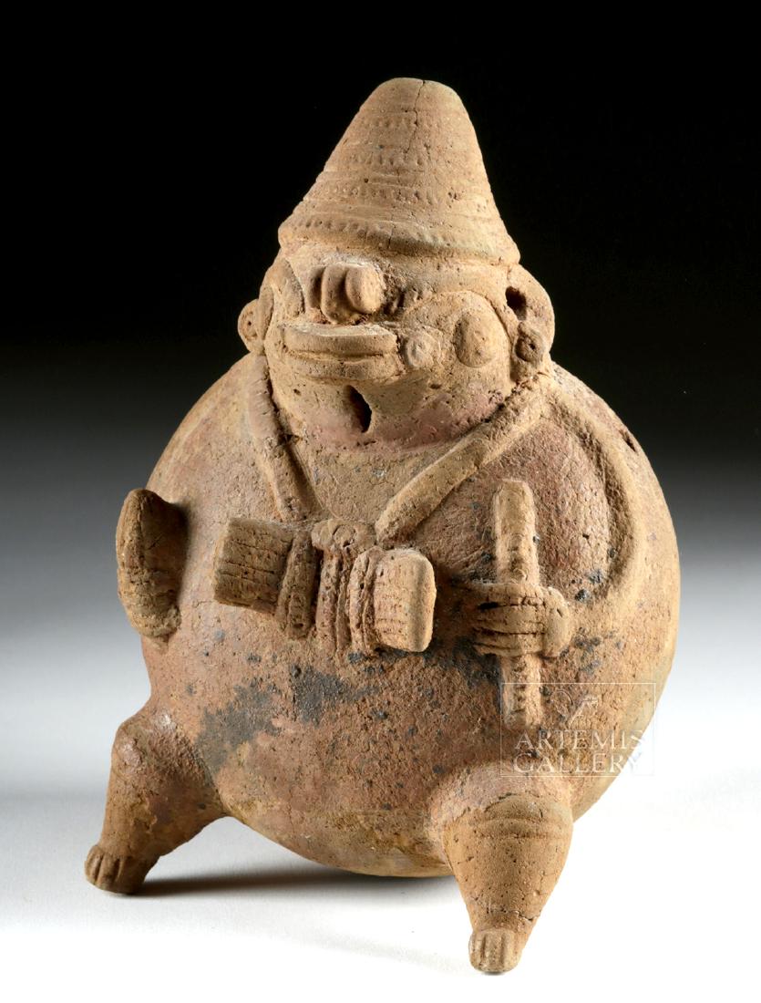 Large Costa Rican Pottery Whistle Figure: Pre-Columbian, Central America, Costa Rica, ca. 800 to 1200 CE. A rotund pottery figure seated upon a pair of conical legs and a rounded base. The figure has sinuous arms holding corn in one hand and