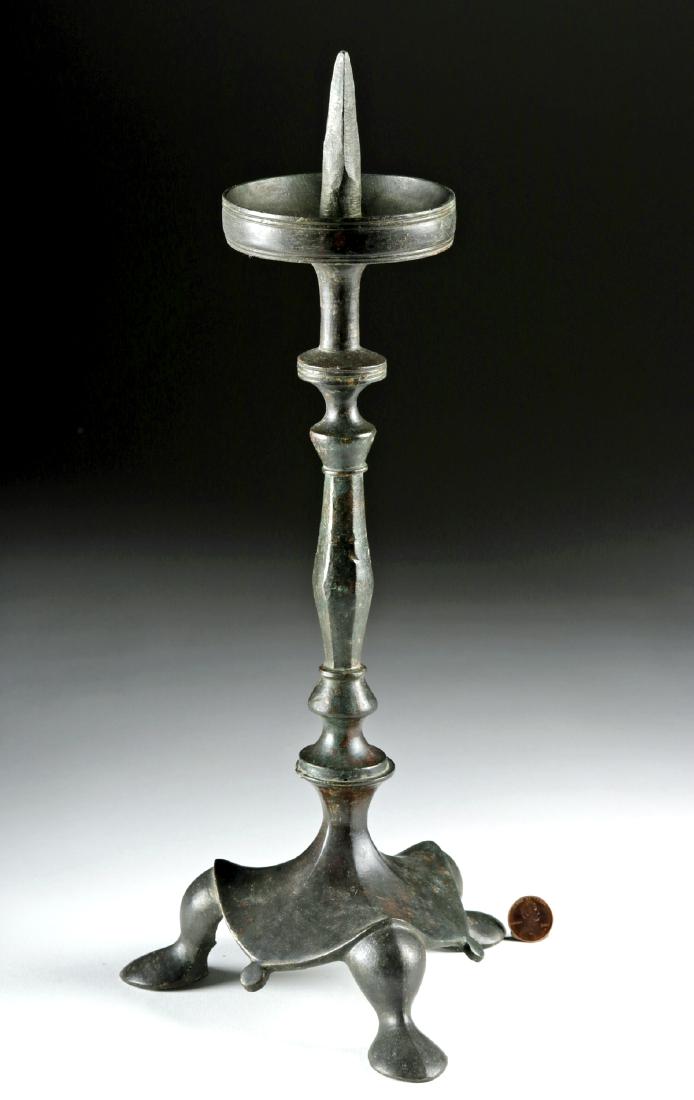 Late Roman / Byzantine Bronze Lamp Stand: Late Roman or early Byzantine Empire, ca. 500 to 800 CE. A cast bronze decorative tripod stand for an oil lamp. The feet are rounded, abstract forms that suggest the paws of an animal; a heavy, skirt-