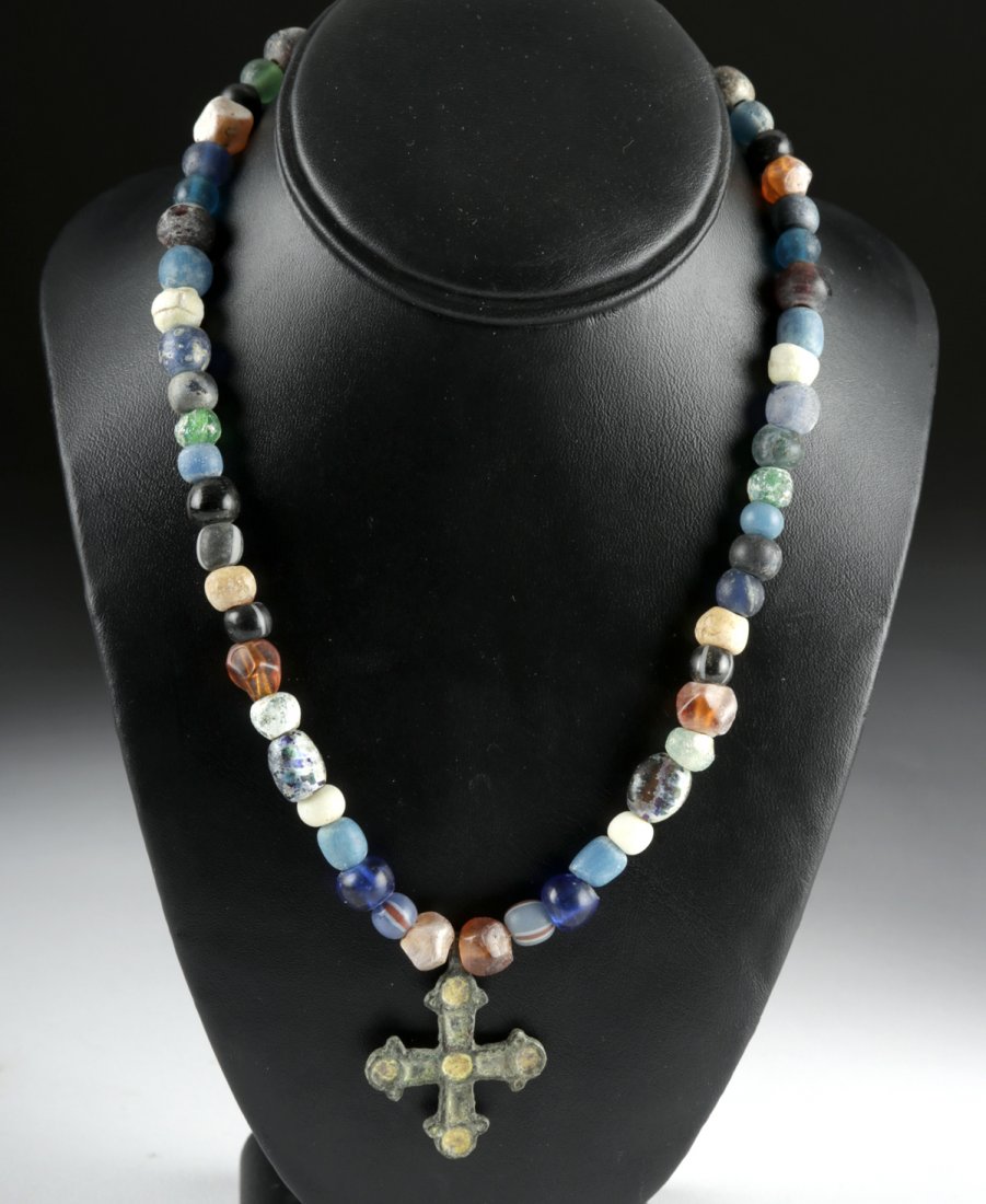 Necklace w/ Viking Glass Beads, Enameled Bronze Cross: Northern Europe, Viking or Norse culture, ca. 9th to 12th century CE. A beautiful necklace boasting a cast-bronze cross of a dark-green hue with inlaid creamy yellow enamel as the central pendant. The