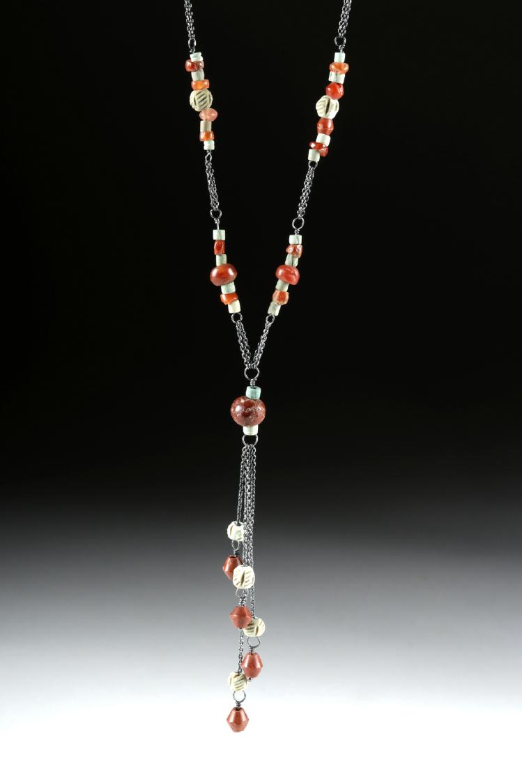Sumerian Carnelian, Faience, & Paste Glass Necklace: Ancient Near East, Sumeria, ca. 3rd to 2nd millennium BCE. A collection of 31 ancient carnelian beads of various shapes - rounded, biconical ovoid, tubular, and seed beads, 30 paste glass seed beads o