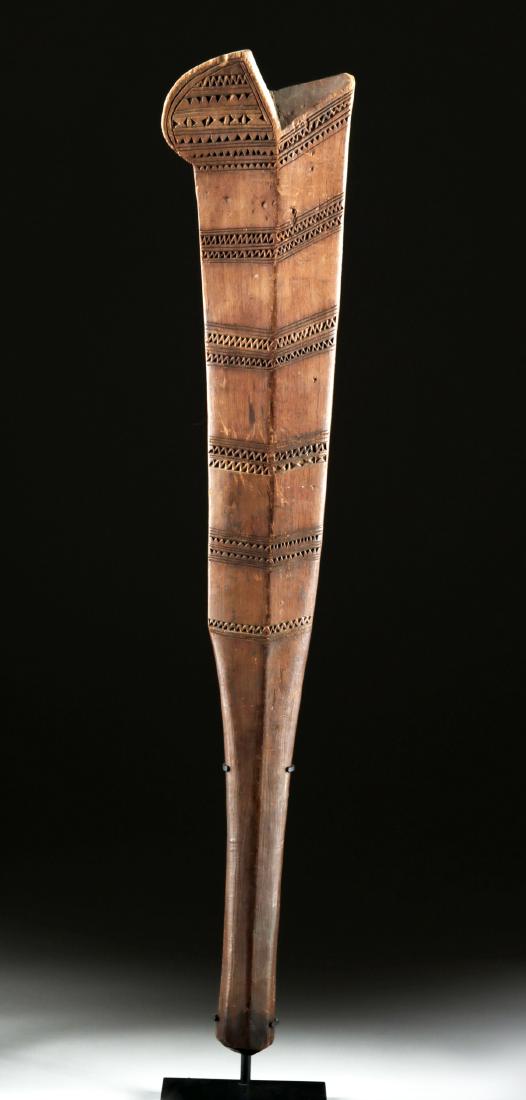 19th C. Samoan Wooden War Club: Oceania, Samoa or possibly Fiji, ca. late 19th century CE. A large, hand-carved wooden war club with a flat, blade-like face carved as one with a long, cylindrical handle. The maker incised repeated b