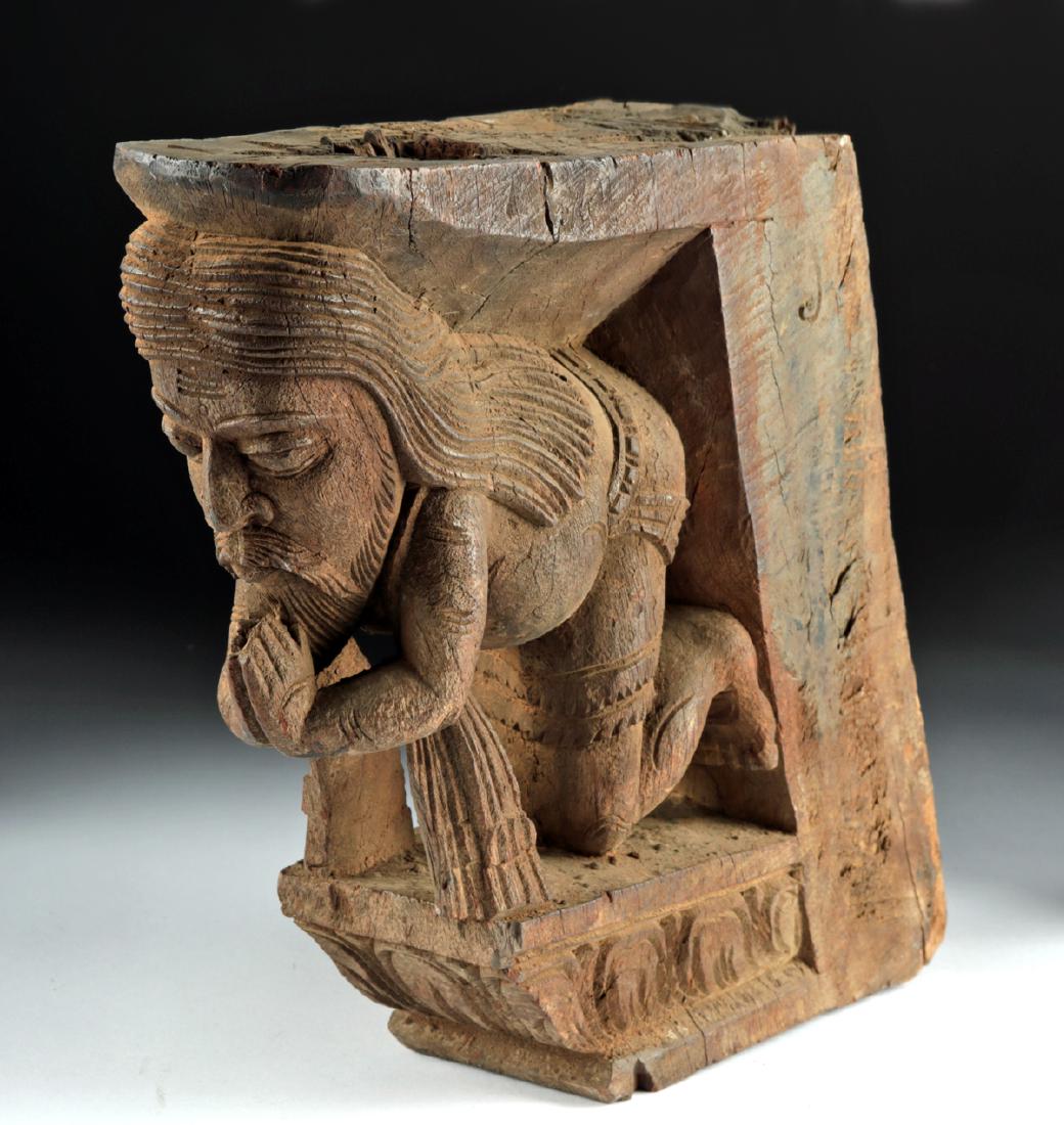 19th C. Indian Wood Shaivite Saint Corbel: Central Asia, India, ca. mid 19th century CE. A beautifully carved wooden corbel depicting a praying man. The corbel has a flat base that flares outward, its edges carved with lotus flowers in relief.