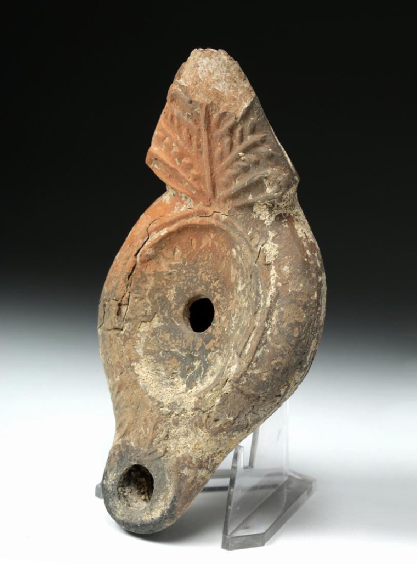 Roman Holy Land Redware Oil Lamp: **Originally Listed At $50** Roman, Roman Holy Land, ca. 3rd to 4th century CE. A mold-made terracotta oil lamp, light-orange and gray in color, with a slight concave base, rolled sides, rounded shoul