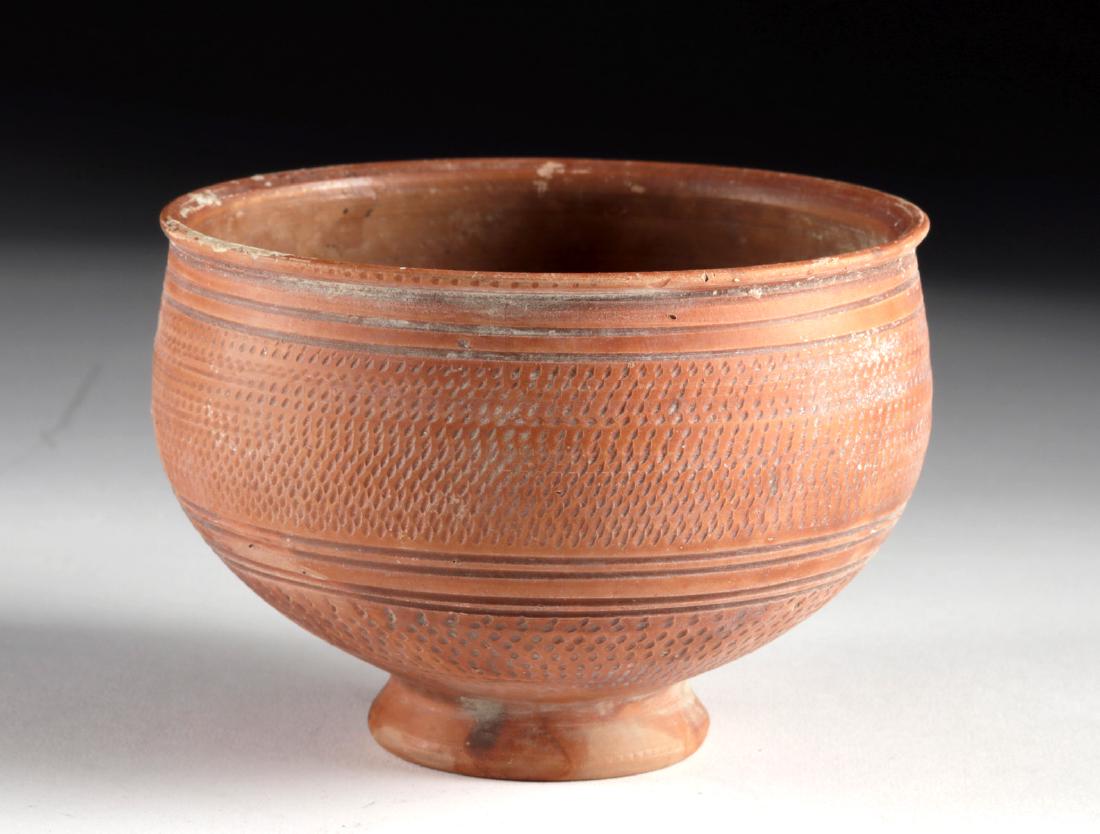 British-Romano Redware Bowl w/ Stippled Motifs: Roman, Roman-controlled Britain, ca. 1st to 3rd century CE. A fine redware pottery bowl resting atop an integral concave foot. The round-bodied vessel has rolling walls, a deep basin, and a gently-tap