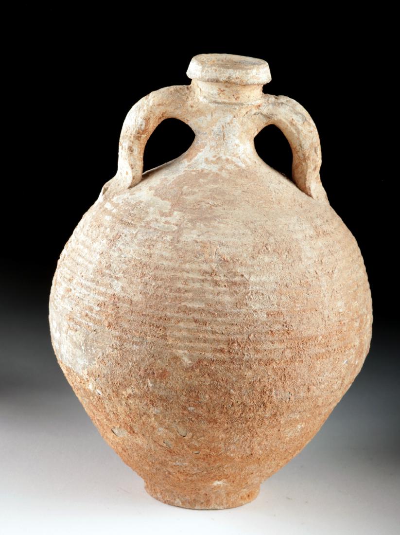 Beautiful Roman Pottery Amphora: Roman, early Imperial Period, ca. 1st to 2nd century CE. A lovely wheel-thrown pottery amphora with a petite base, a spherical body with an elongated lower section, a narrow neck, a collared rim meant