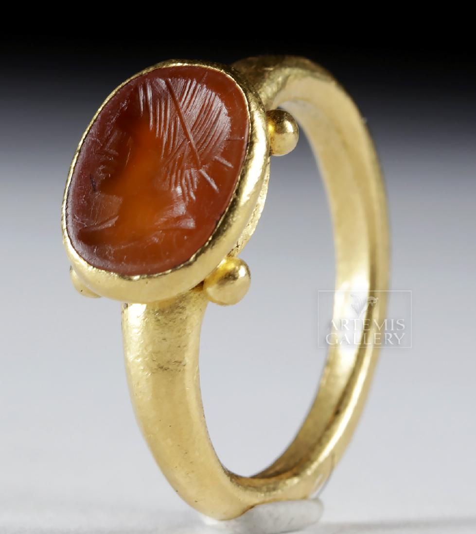Roman 22K+ Gold Ring w/ Carnelian Intaglio - Helios: Roman, Imperial Period, ca. 1st to 3rd century CE. A striking gold ring comprised of 95% gold (equivalent to 22K+) with a carnelian intaglio depicting the profiled head of Helios wearing his spiked he