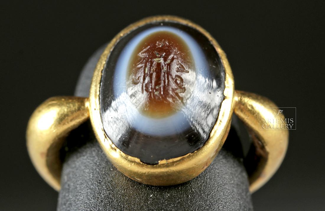 Roman 22k+Gold Ring w/ Agate Intaglio: Roman, Imperial Period, ca. 2nd to 4th century CE. A fine and petite ring comprised of 97% gold (equivalent to 22K+ gold) with an curved band and an ovoid bezel. Within the bezel is a stunning banded 