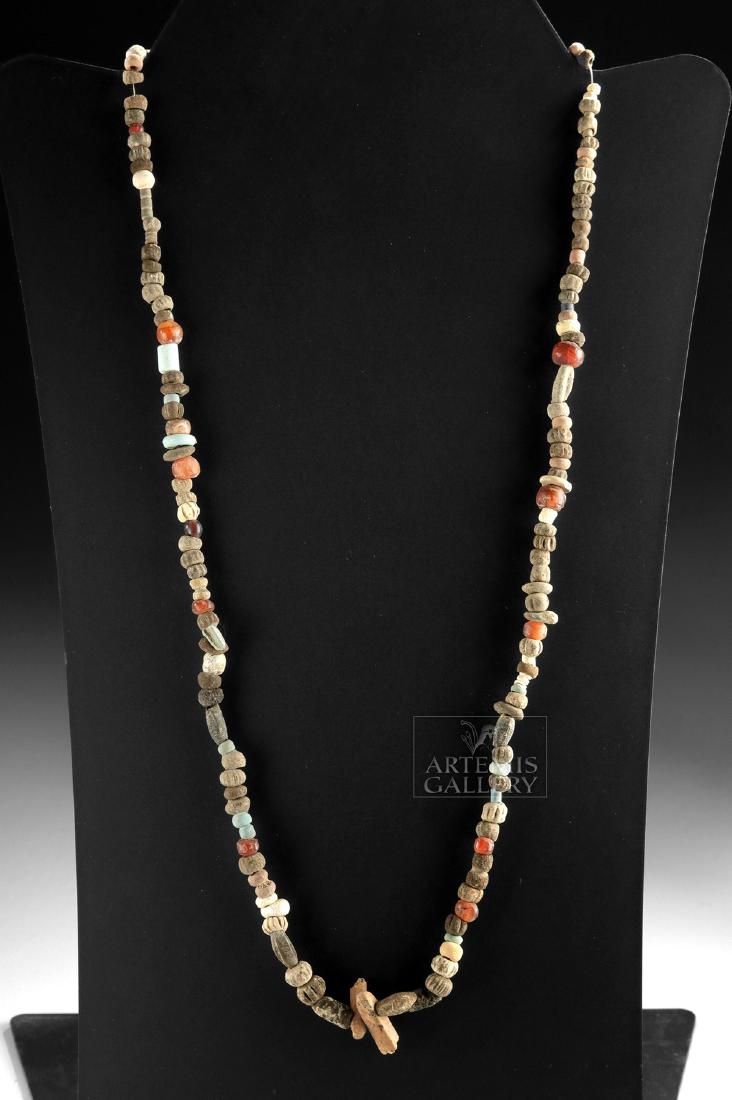 Sumer Faience, Glass, Shell, & Carnelian Bead Necklace: **First Time At Auction** Ancient Near East, Sumer, ca. 3rd to 2nd millennium BCE. A fascinating strand of ancient beads, composed of 11 hand-carved carnelian beads, 2 small glass beads, and dozens of