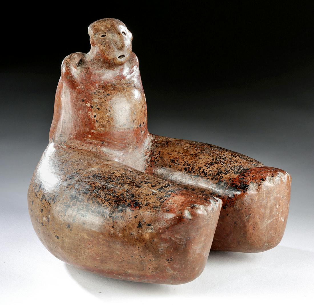 Unusual Colima Redware Seated Figure w/ Huge Legs: Pre-Columbian, West Mexico, Colima, ca. 300 BCE to 300 CE. A burnished redware vessel depicting a seated figure who presents a most unusual form. Holding diminutive arms up and behind to support the l