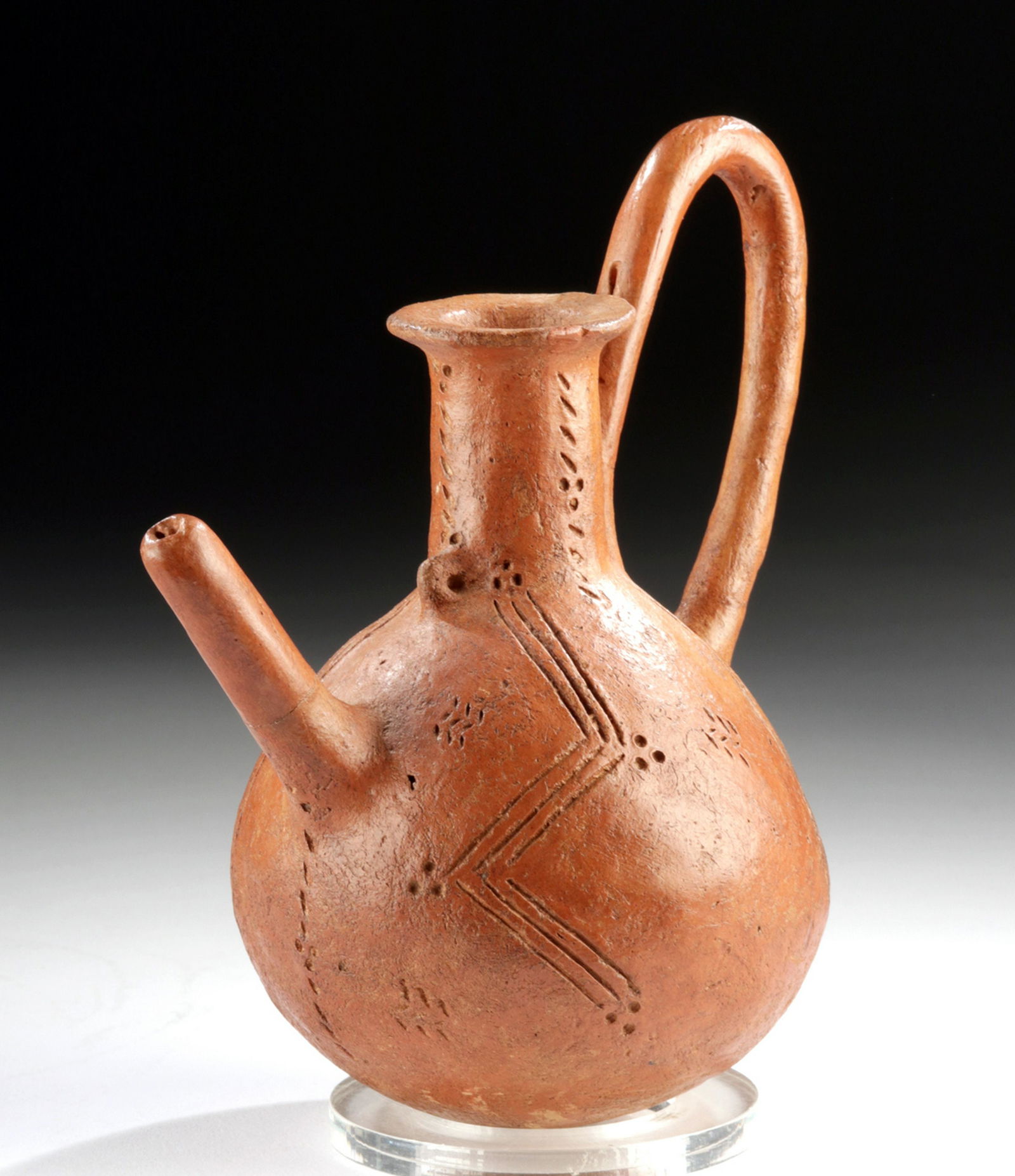 Cypriot Redware Pitcher w/ Incised Decoration: Ancient Mediterranean, Cyprus, Middle Bronze Age, ca. 2000 to 1650 BCE. An interestingly-shaped pottery pouring vessel with a single large loop handle and a long thin spout projecting from one side in