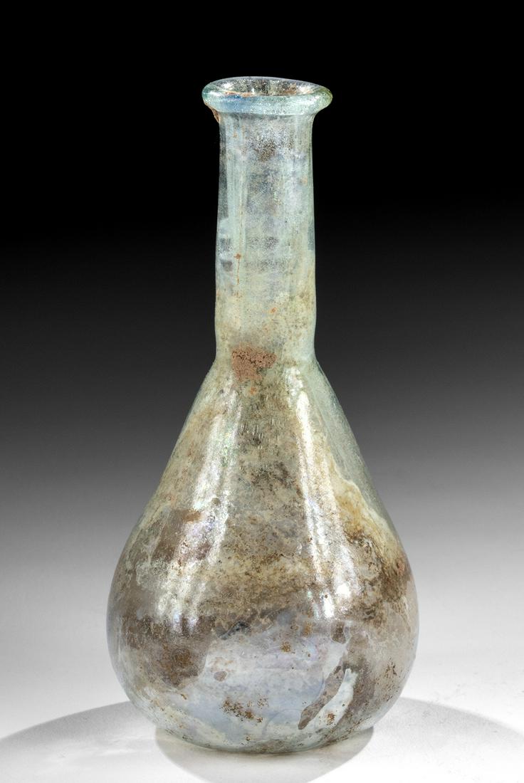 Petite Roman Glass Flask: Roman, early Imperial Period, ca. 1st to early 2nd century CE. A lovely flask of a petite size, free-blown from semi-translucent glass of a pale blue-green hue. The vessel is defined by a planar base,