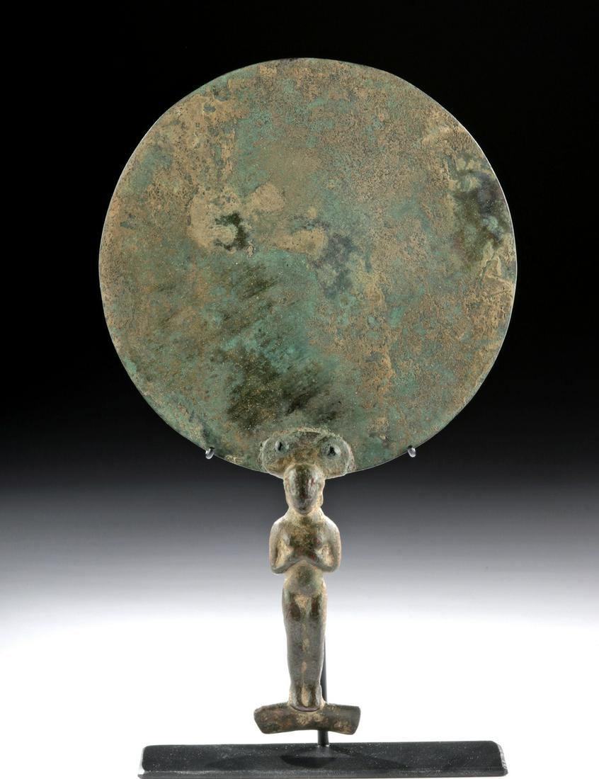 Hellenistic Greek Bronze Mirror w/ Figural Handle: Greece, Hellenistic period, ca. late 4th to 2nd century BCE. A graceful cast bronze mirror, composed of a slightly concave thin disc with a short lip which would have once held a highly polished refle