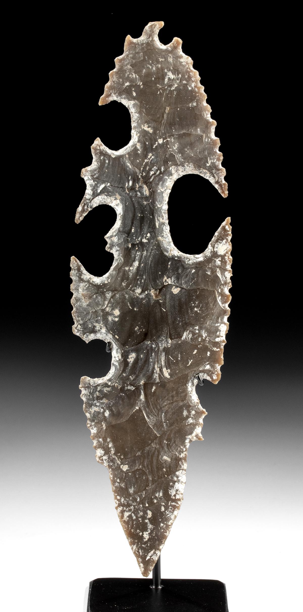 Tall Maya Eccentric Flint w/ God K: Pre-Columbian, Mexico and northern Central America, Maya Territories, Late Classic, ca. 550 to 900 CE. A fascinating mottled grey "eccentric" flint of elongated form, its sides knapped to such thin, s