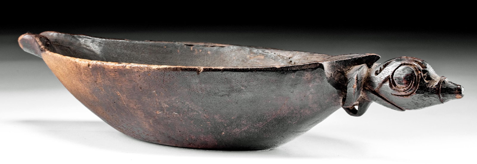 Early 20th C. Dayak Dark Wooden Ritual Bowl - Aso: Indonesia, Borneo, Central Kalimantan, Kayanic Dayak peoples, ca. early to mid 20th century CE. A beautiful dark wood bowl, long and leaf-shaped, with a shallow interior and gently sloping walls that 