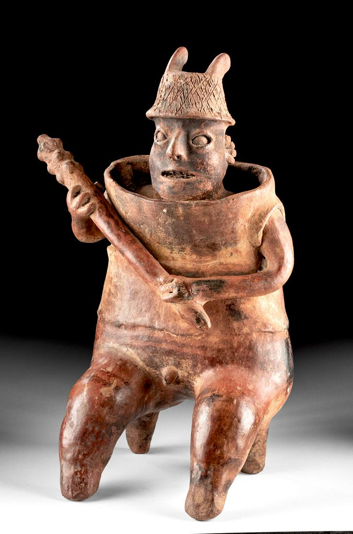 Nayarit Pottery Seated Male Warrior w/ Barrel Armor: Pre-Columbian, West Mexico, Nayarit, San Sebastian style, Protoclassic Period, ca. 100 BCE to 250 CE. A wonderful hand-built and highly-burnished pottery warrior of a sizable form seated upon bent leg