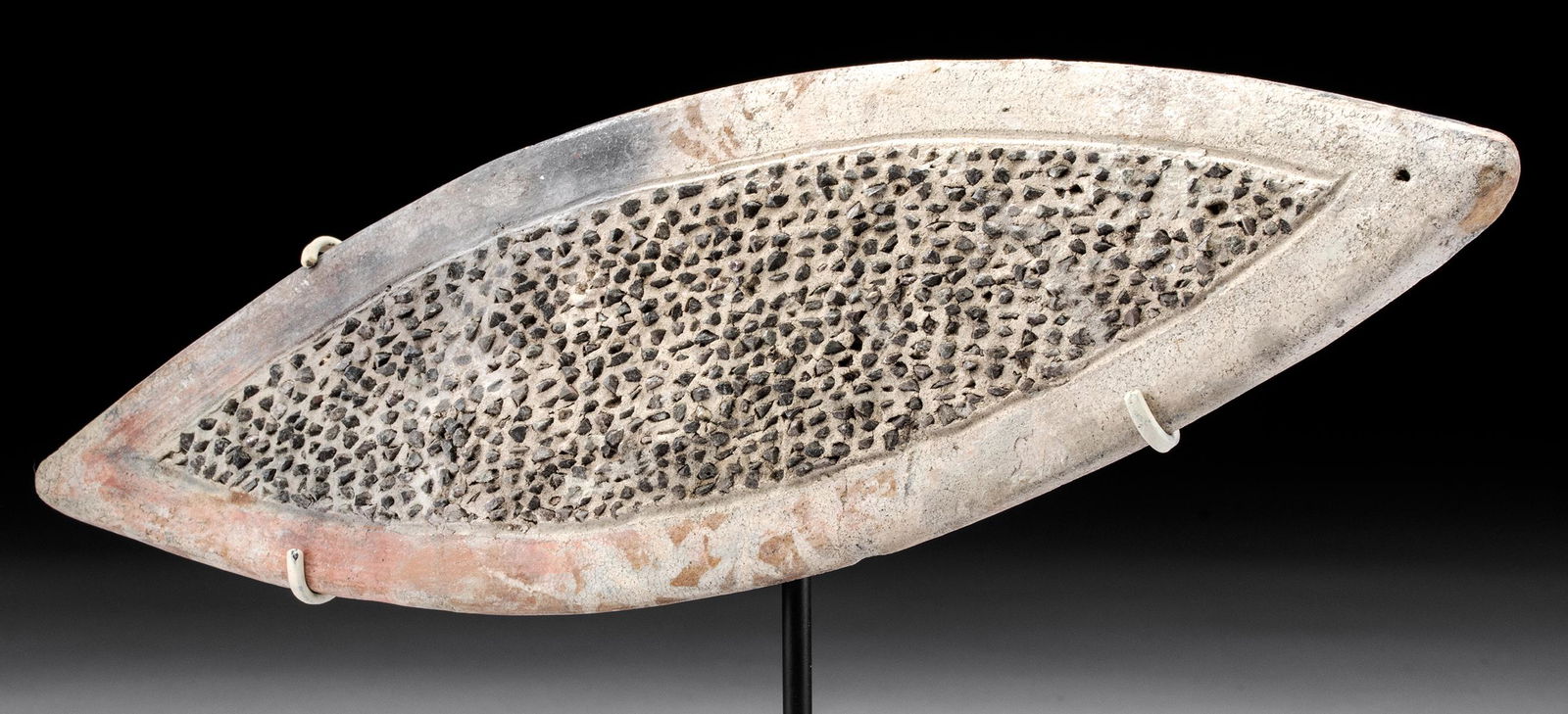 La Tolita Terracotta & Stone Fish Grater: Pre-Columbian, Colombia and Ecuador, La Tolita (sometimes Tumaco) culture, ca. 350 BCE to 350 CE. A hand-built pottery grater (known as a rollador) of an abstract fish form. The elongated ovoid body t