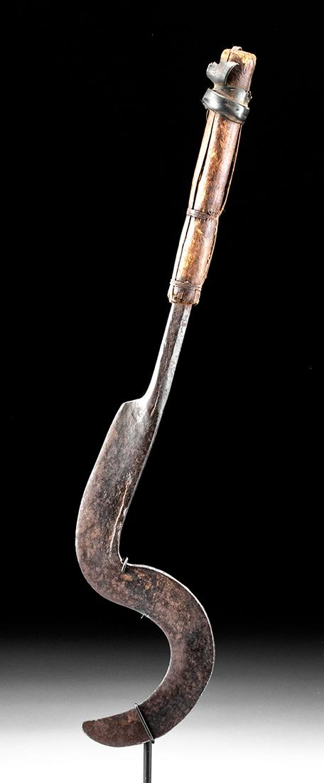 20th C. African Kirdi Iron Throwing Knife / Currency: Central Africa, Cameroon, Kirdi people, ca. early to mid-20th century CE. A forged-iron throwing knife that has a sturdy tang and a sickle-shaped blade with a thick spine and a sharpened interior edge