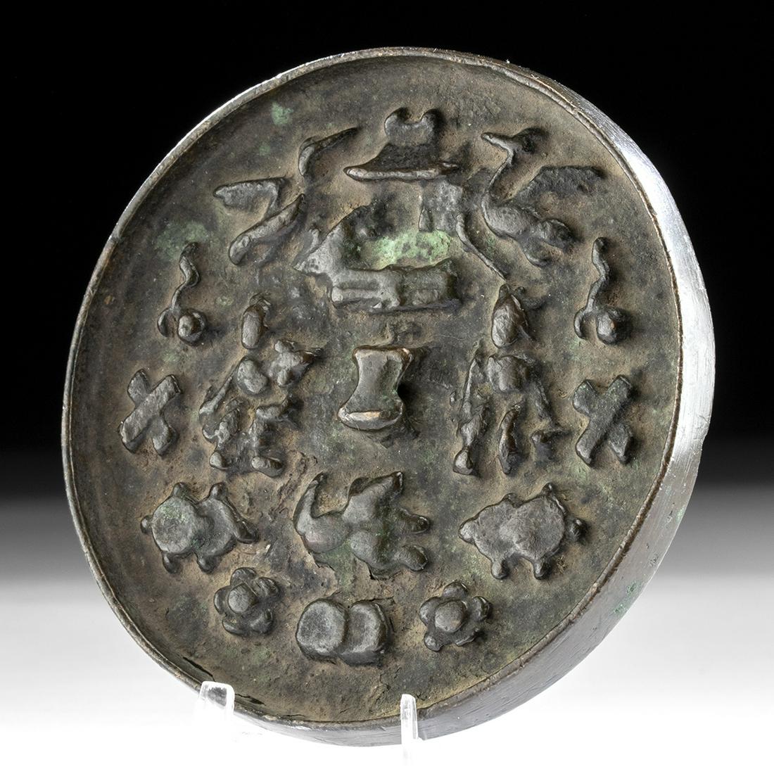 Chinese Han Dynasty Bronze Hand Mirror w/ Nature Scene: East Asia, China, Han Dynasty, ca. 206 BCE to 220 CE. A circular bronze mirror, cast in low relief, with a perforated rectangular boss through which a cord would have been threaded for easier grasping