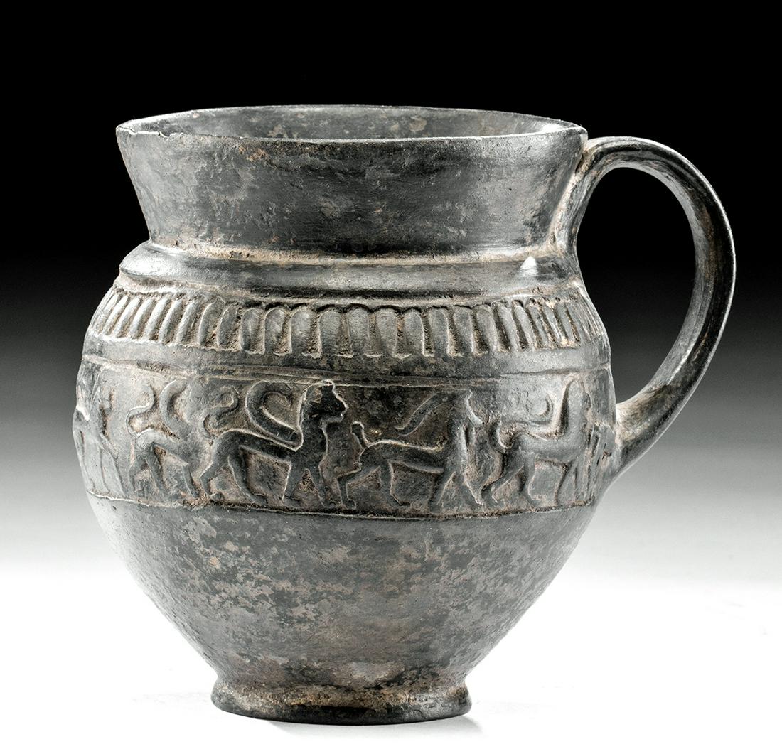 Etruscan Bucchero Pitcher w/ Animals, ex-Christie's: Classical World, Italy, Etruria, ca. early 6th century BCE. A wonderful wheel-thrown pottery pitcher with a petite circular base, an apple-shaped body with a rounded shoulder, a wide, conical neck wit