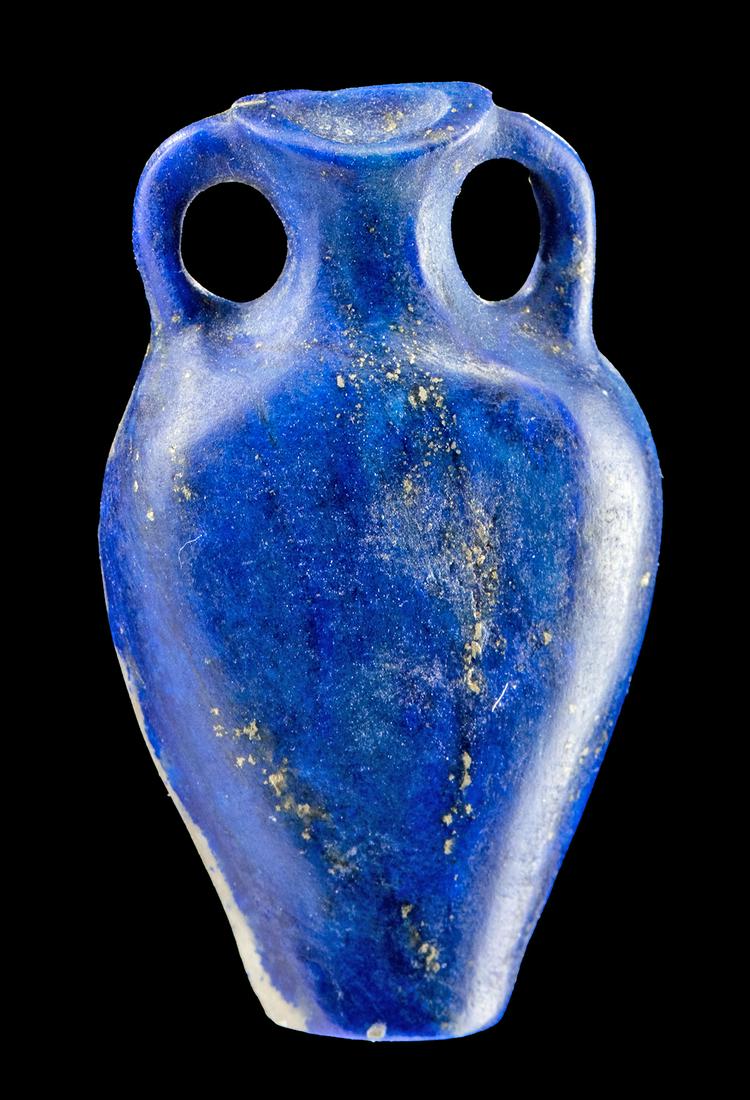 Rare Egyptian Lapis Lazuli Amphora Applique: Ancient Egypt, New Kingdom, ca. 1550 to 1070 BCE. A deep blue lapis lazuli applique in the form of an amphora, carved with a graceful curved body, two looping handles, a thin neck, and a flaring mouth