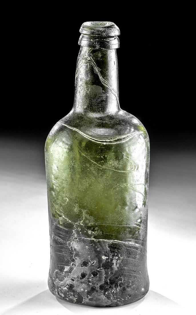 1770s European Green Glass Bottle: Northern Europe or British North American colonies, ca. 1770s to 1790s CE. A nice example of a squat cylinder green glass bottle, popular in the later 18th century for holding port and other fortified