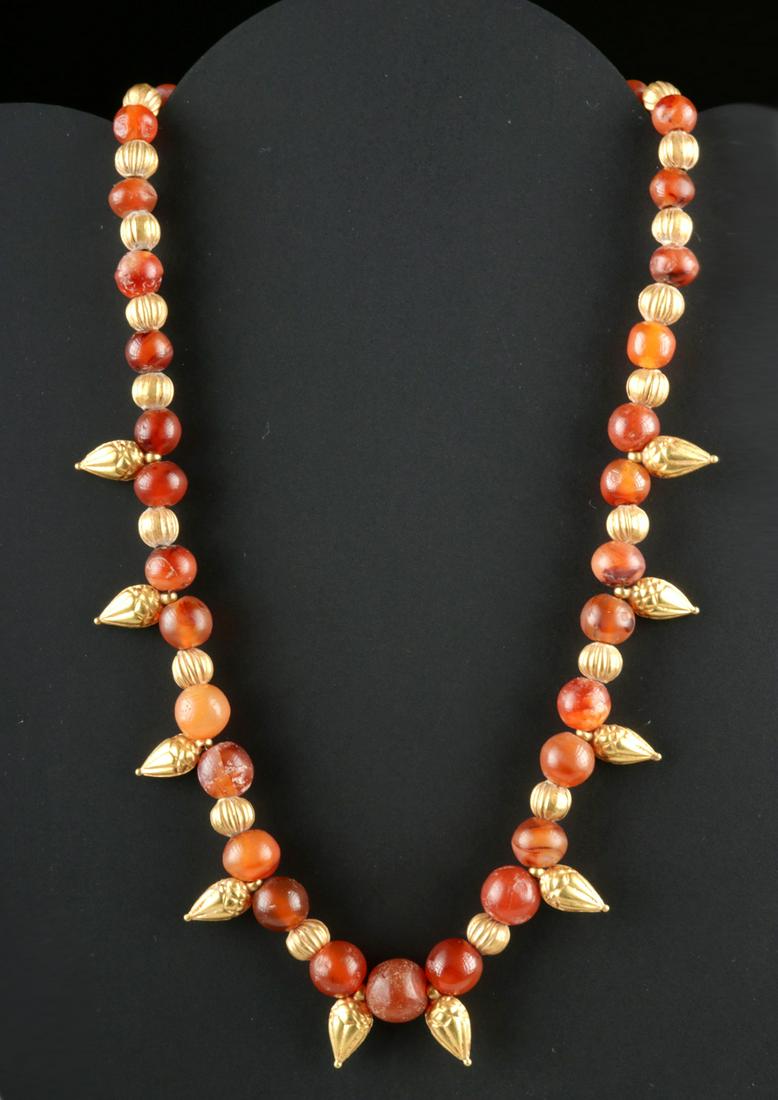 Published Achaemenid 20K+ Gold / Carnelian Necklace: Ancient Near East, Achaemenid, ca. 5th to 2nd century BCE. A stunning gold (92% gold, equivalent to 20K+) and carnelian necklace of a sublime presentation. The necklace includes 20 gold spherical bead