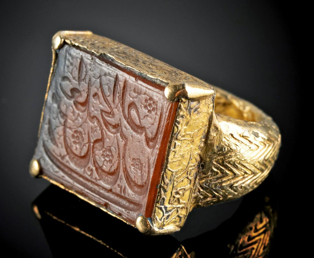 Islamic 18K+ Gold Ring w/ Kufic Carnelian Intaglio: Middle East, Islamic world, ca. 1000 to 1500 CE. Wow! Wow! Wow! A stunning medieval Islamic ring featuring a hand-carved rectangular carnelian intaglio of warm orange hues that is skillfully engraved 