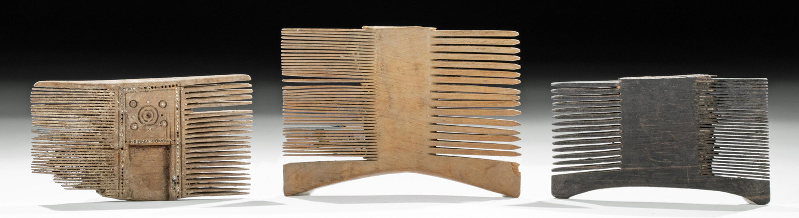 Egyptian Coptic Wooden Combs - Group of 3: Ancient Egypt, Coptic culture, ca. 1st century BCE to 1st century CE. A trio of finely preserved wooden combs, two with curved ends, the third with a more elaborate decorative program at its center an