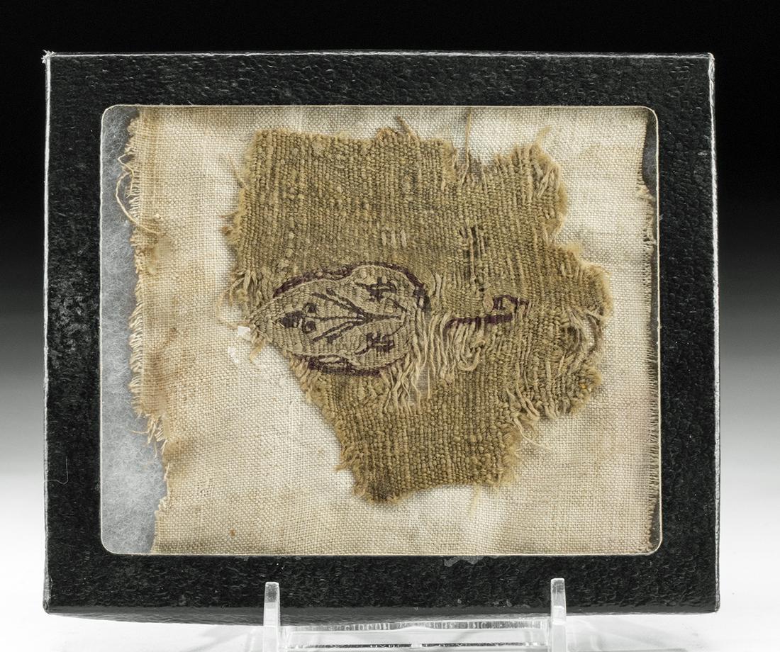 Egyptian Coptic Textile Fragment w/ Leaf: Egypt, Coptic culture, ca. 2nd to 5th century CE. A fine textile fragment composed of tightly woven natural cotton fibers and dyed in a hue of beige. Within the body is a crimson-hued leaf bearing flo