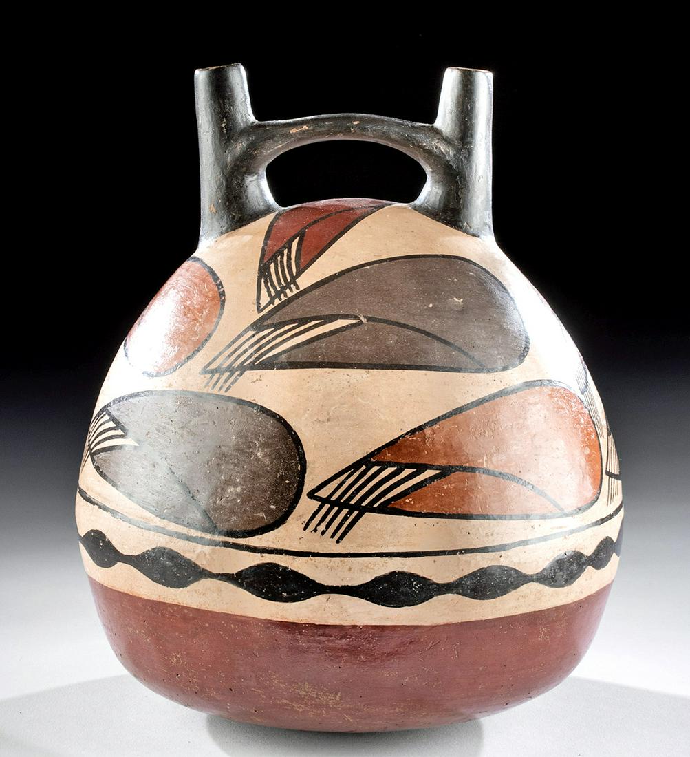 Nazca Polychrome Stirrup Vessel w/ Corn Cobs: Pre-Columbian, South Coast Peru, Nazca, ca. 100 to 300 CE. An attractive stirrup vessel presenting an ample piriform polychrome body topped by a black double-spouted stirrup. The iconographic/decorati